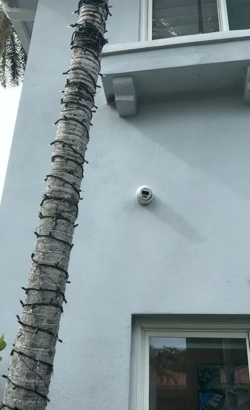 Security camera mounted on a stucco exterior wall