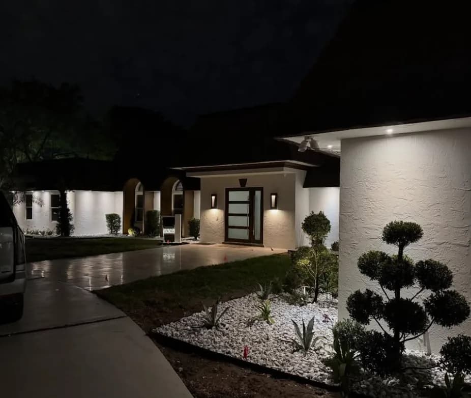 Modern home entry with landscape lighting at night